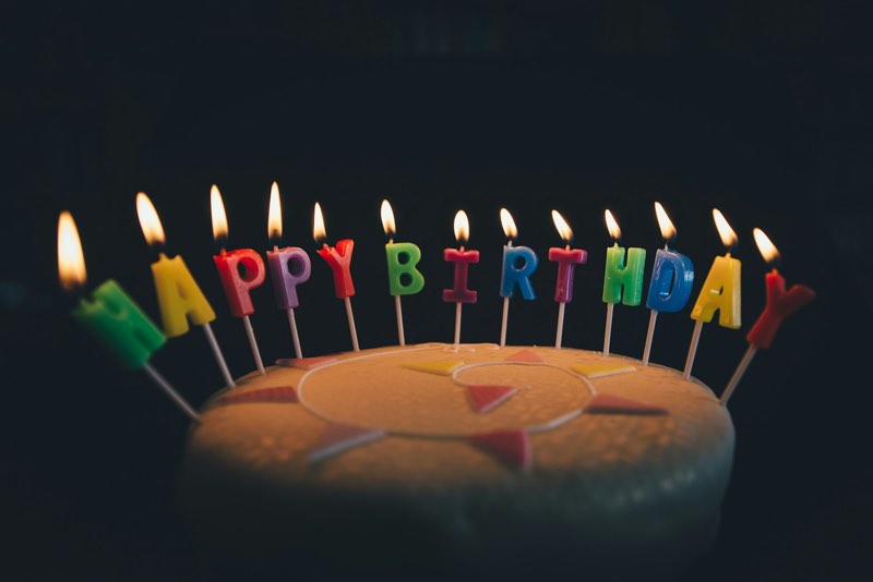 Birthday cake with lit Happy Birthday candles