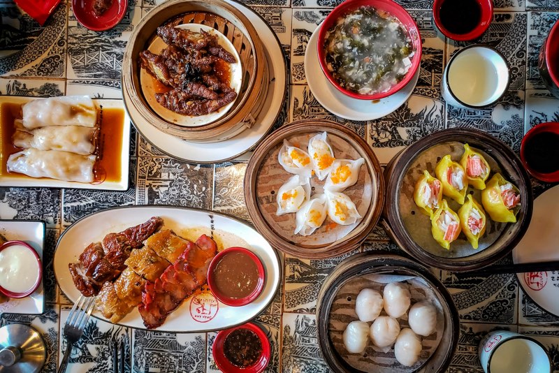 Overhead view of a table covered with dim sum baskets and Chinese dishes